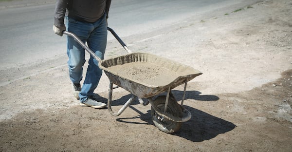 construction-worker-pushing-wheelbarrow-cement