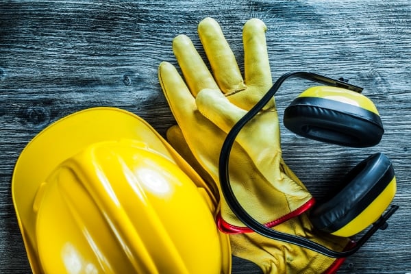 earmuffs-protective-gloves-building-helmet-wooden-board